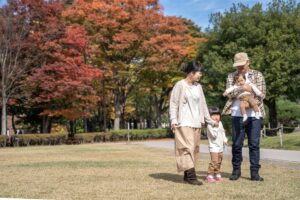 秋の公園で遊ぶ家族