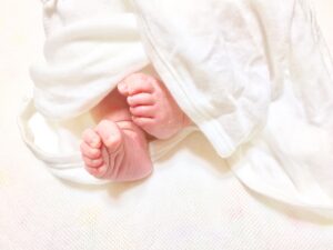 肌着を着た入生児の足