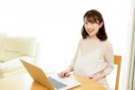 パソコンを操作す妊娠女性